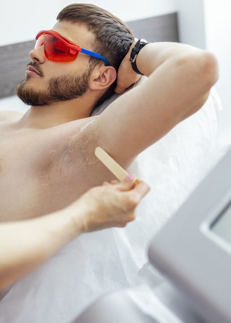 Achselbehandlung bei einem Kunden mit Schutzbrille